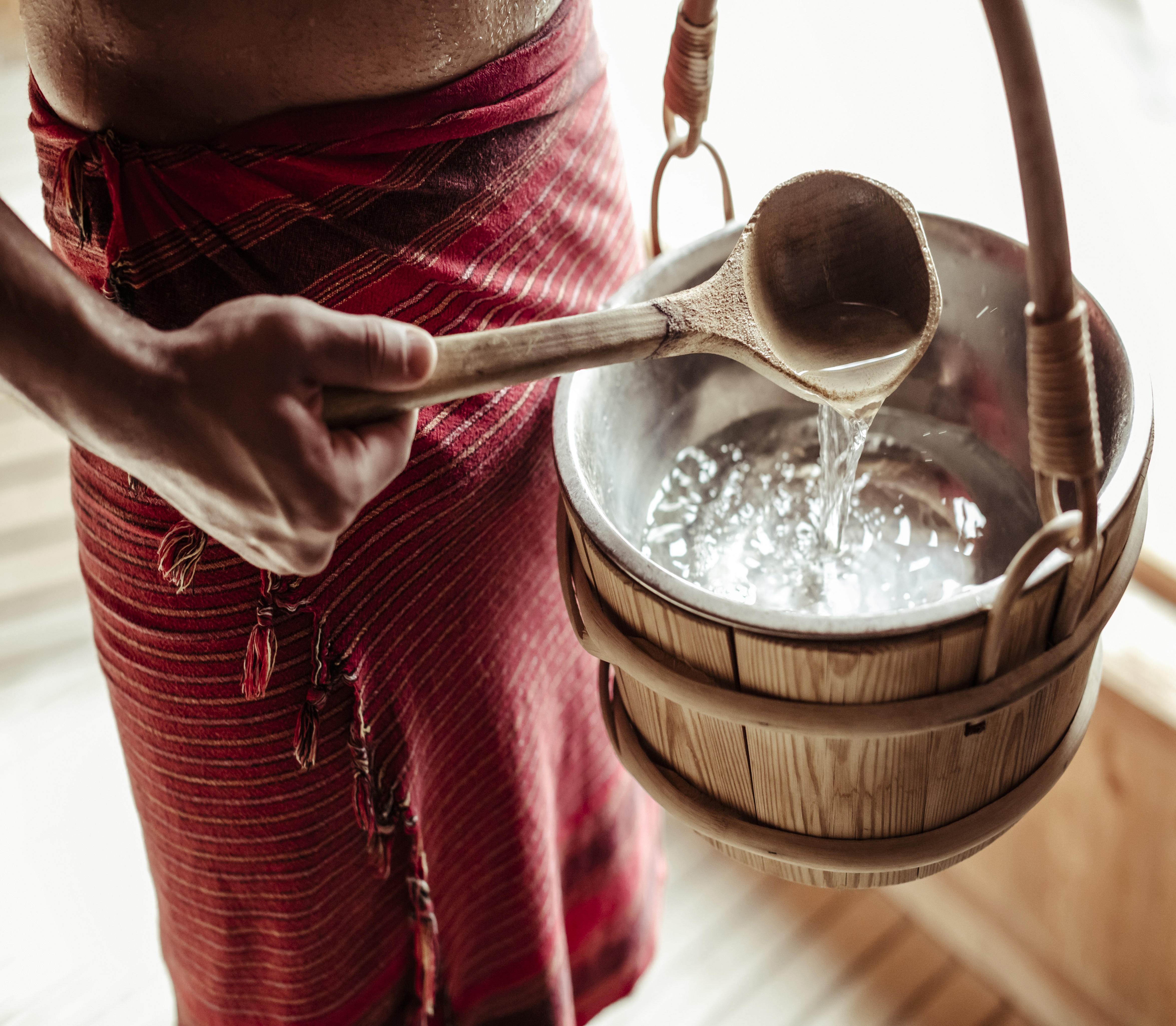 Mann in der Sauna mit Aufguss-Eimer